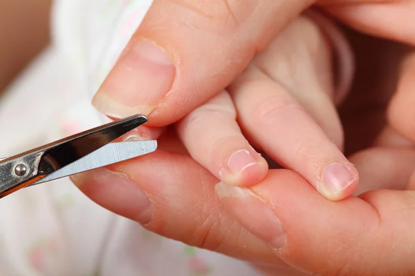 Мама стрижет ногти малышу — стоковое фото