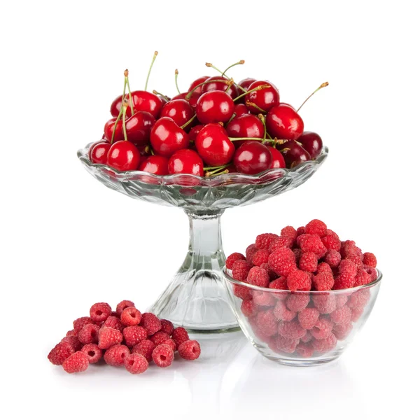 Свежая малина и красные вишни в чаше, изолированной на белом — стоковое фото