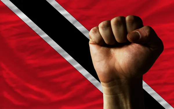 Hard fist in front of trinidad tobago flag symbolizing power — Stock Photo, Image