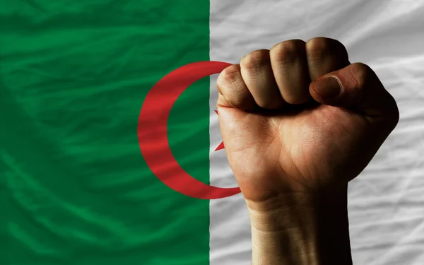 Poing dur devant le drapeau d'algérie symbolisant le pouvoir — Photo