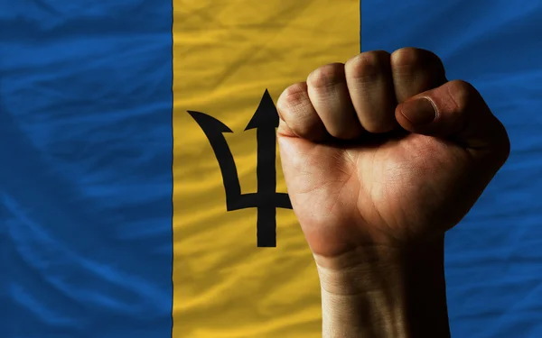 Жесткий кулак перед флагом Барбадоса символизирует власть — стоковое фото