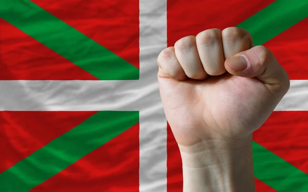 Жесткий кулак перед баскским флагом символизирует власть — стоковое фото