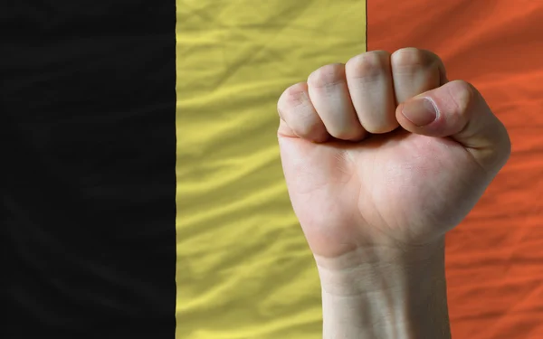 Puño duro frente a la bandera de Bélgica que simboliza el poder — Foto de Stock
