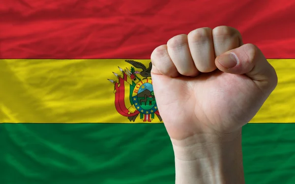 Pugno duro davanti alla bandiera boliviana che simboleggia il potere — Foto Stock
