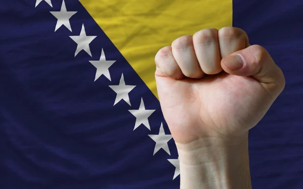 Жесткий кулак перед флагом Боснии и Герцеговины символизирует власть — стоковое фото