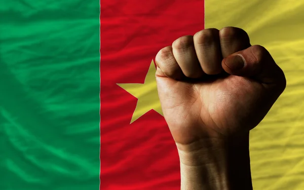 Pugno duro davanti alla bandiera del Camerun che simboleggia il potere — Foto Stock