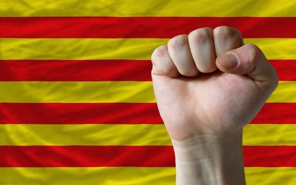 Жесткий кулак перед флагом Каталонии символизирующим власть — стоковое фото