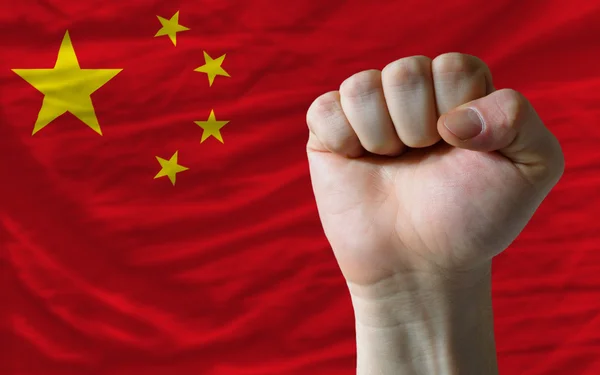 Жесткий кулак перед китайским флагом символизирует власть — стоковое фото