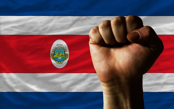 Sert yumruk gücü simgeleyen Kosta Rika bayrağı önünde — Stok fotoğraf