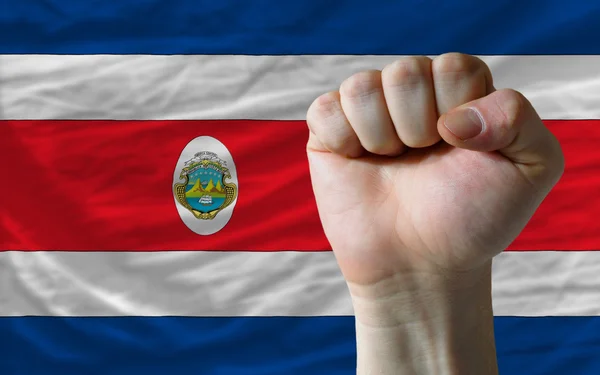 Sert yumruk gücü simgeleyen Kosta Rika bayrağı önünde — Stok fotoğraf