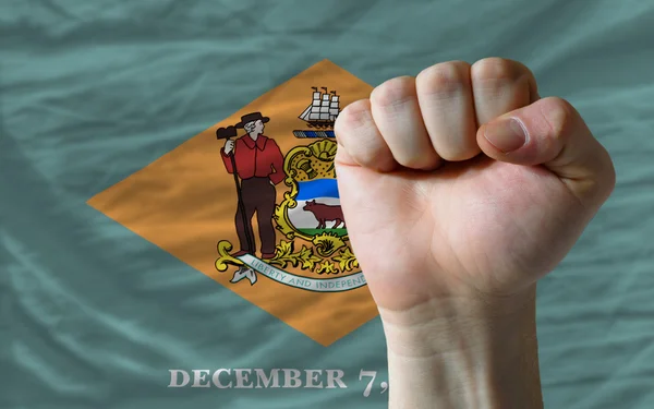 Bandera del estado de Delaware con el puño duro delante de él simboliz —  Fotos de Stock