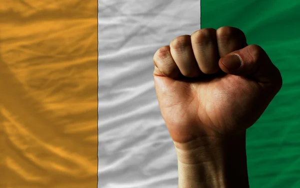 Hårda näve framför Elfenbenskusten flaggan symboliserar makt — Stockfoto