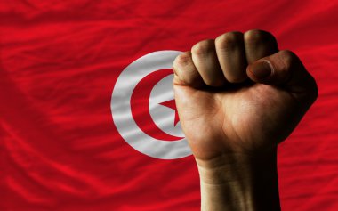 Hard fist in front of tunisia flag symbolizing power clipart