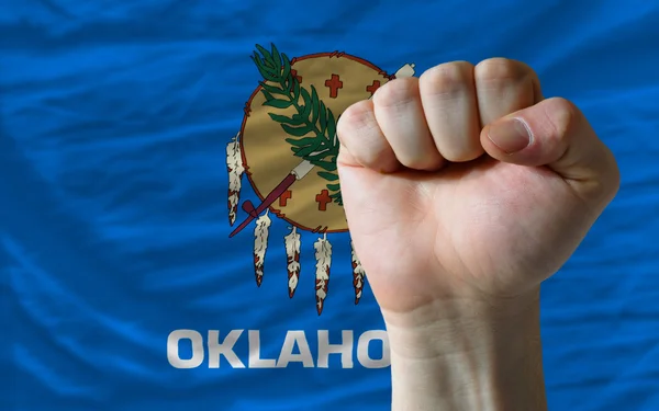Us state flag of oklahoma with hard fist in front of it symboliz — Stock Photo, Image