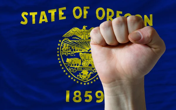 Us state flag of oregon with hard fist in front of it symbolizin — Stock Photo, Image