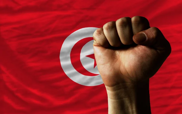 Puño duro frente a la bandera de Tunisia que simboliza el poder — Foto de Stock