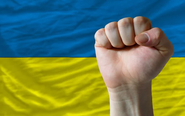 Tvrdá pěst před Ukrajina vlajku symbolizující sílu — Stock fotografie