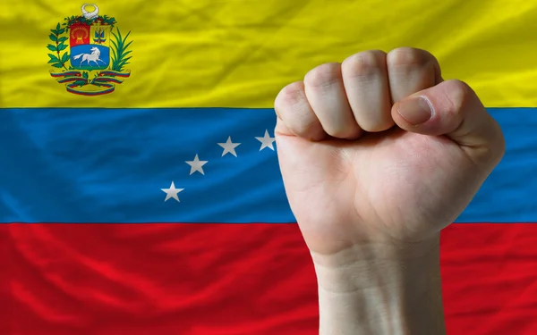 Hard fist in front of venezuela flag symbolizing power — Stock Photo, Image