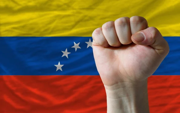Punho duro na frente da bandeira venezuela simbolizando poder — Fotografia de Stock