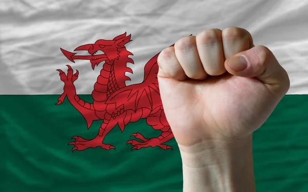 Puño duro frente a la bandera de Gales simbolizando el poder — Foto de Stock