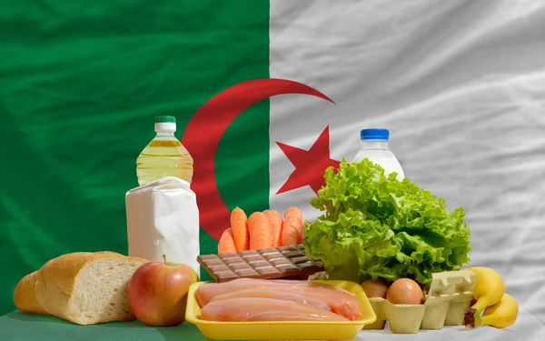 Abarrotes básicos de alimentos frente a la bandera nacional de algeria — Foto de Stock