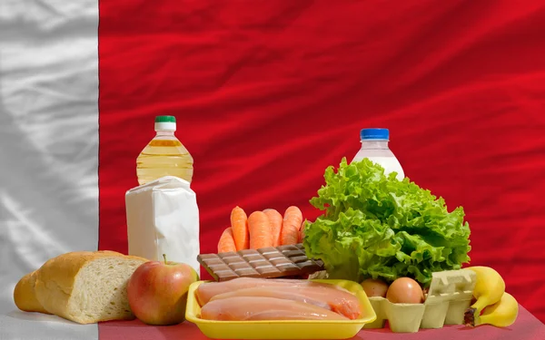 Основные продовольственные товары перед национальным флагом Бахрейна — стоковое фото