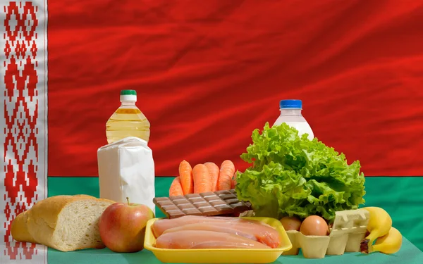 Abarrotes básicos de alimentos frente a la bandera nacional belarus — Foto de Stock
