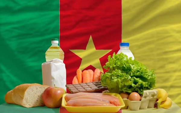 Mercearia alimentar básica em frente à bandeira nacional dos Camarões — Fotografia de Stock