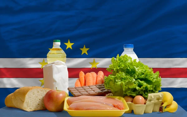 Основные продовольственные товары перед национальным флагом Кабо-Верде — стоковое фото