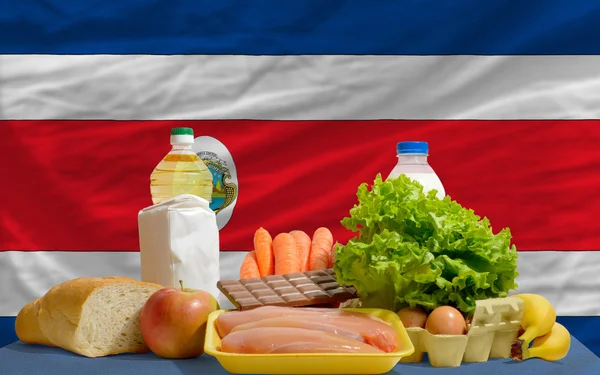 Abarrotes básicos de alimentos frente a la bandera nacional de Costa Rica — Foto de Stock