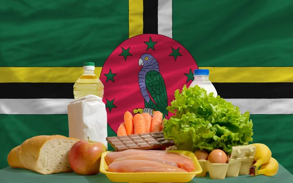 Épicerie alimentaire de base devant le drapeau national de la Dominique — Photo
