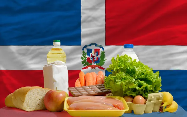 Stock image Basic food groceries in front of dominican national flag