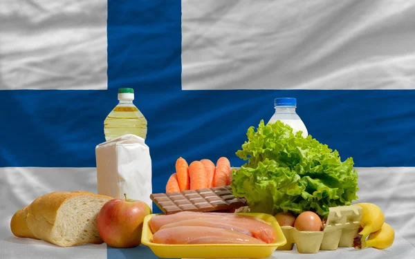 Abarrotes de alimentos básicos frente a la bandera nacional de Finlandia — Foto de Stock