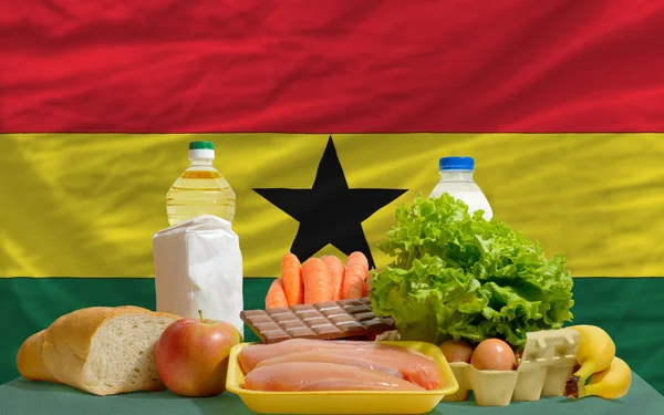 Mercearia básica de alimentos em frente à bandeira nacional do Gana — Fotografia de Stock