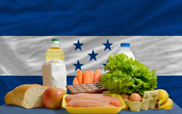 Основные продукты питания перед национальным флагом Гондураса — стоковое фото