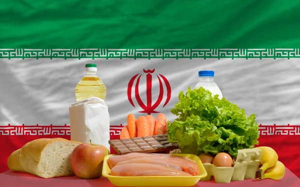 Abarrotes de alimentos básicos frente a la bandera nacional de Irán — Foto de Stock