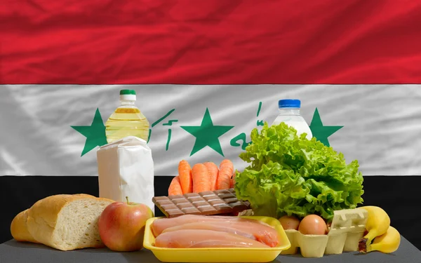 Produits alimentaires de base devant le drapeau national iraq — Photo
