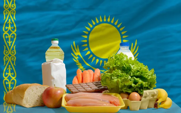 Mercearia básica de alimentos em frente à bandeira nacional do Cazaquistão — Fotografia de Stock