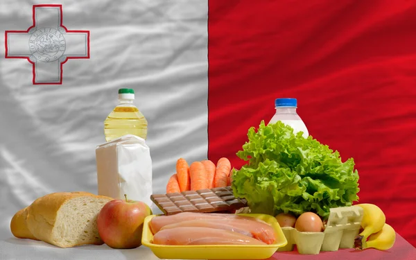 Mercearia básica de alimentos em frente à bandeira nacional de malta — Fotografia de Stock
