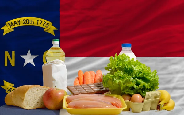 Basic food groceries in front of north carolina us state flag — Stock Photo, Image