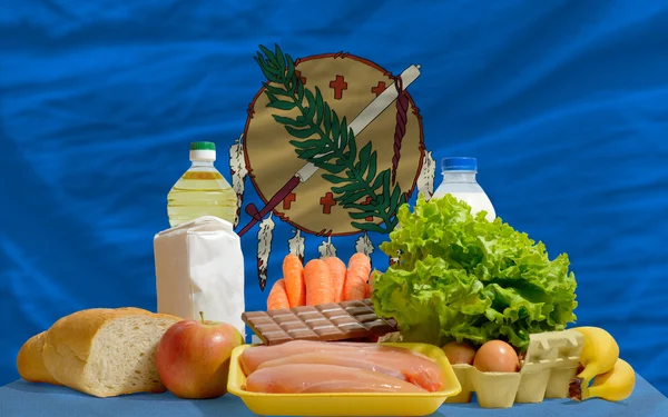 Abarrotes de alimentos básicos frente a la bandera del estado de oklakoma us — Foto de Stock