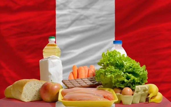 Abarrotes básicos de alimentos frente a la bandera nacional de Perú — Foto de Stock