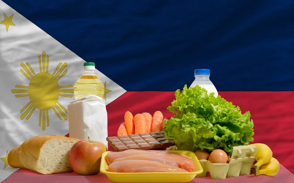 Abarrotes básicos de alimentos frente a la bandera nacional de Filipinas —  Fotos de Stock