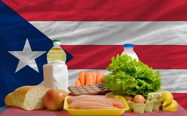 Основные продовольственные товары перед национальным флагом Пуэрторико — стоковое фото