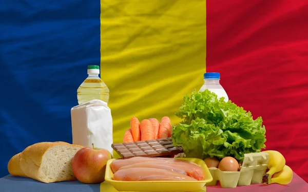Abarrotes de alimentos básicos frente a la bandera nacional romania —  Fotos de Stock