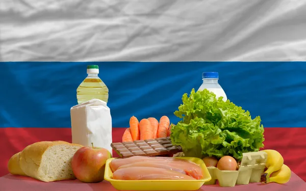 Abarrotes de alimentos básicos frente a la bandera nacional de Rusia —  Fotos de Stock
