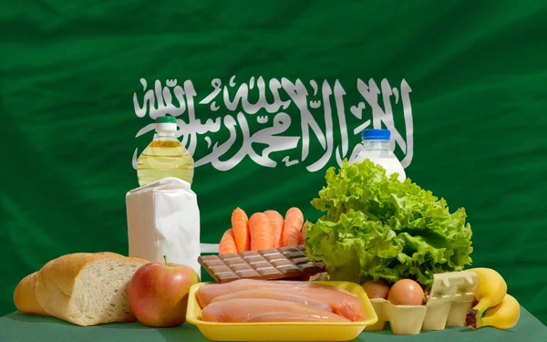 Основные продовольственные товары перед национальным флагом Саудовской Аравии — стоковое фото