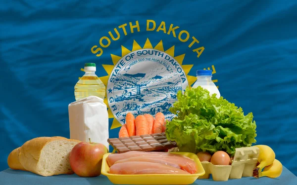 Basic food groceries in front of south dakota us state flag — Stock Photo, Image