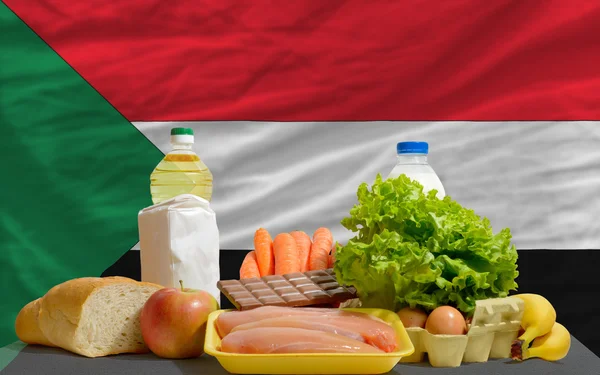 Abarrotes básicos de alimentos frente a la bandera nacional de Sudán —  Fotos de Stock