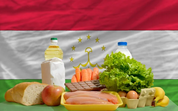 Základní potraviny potraviny před státní vlajka Tádžikistánu — Stock fotografie